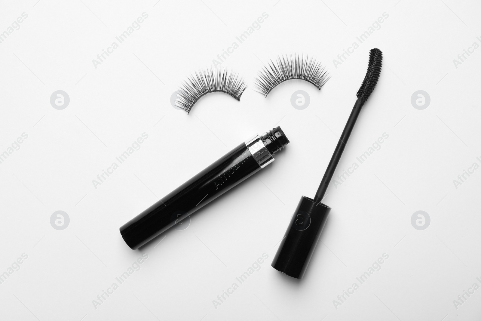 Photo of Flat lay composition of black mascara and false eyelashes on white background