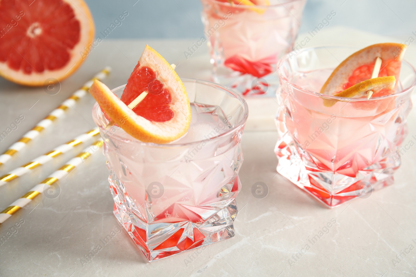 Photo of Glasses with tasty grapefruit cocktails on table