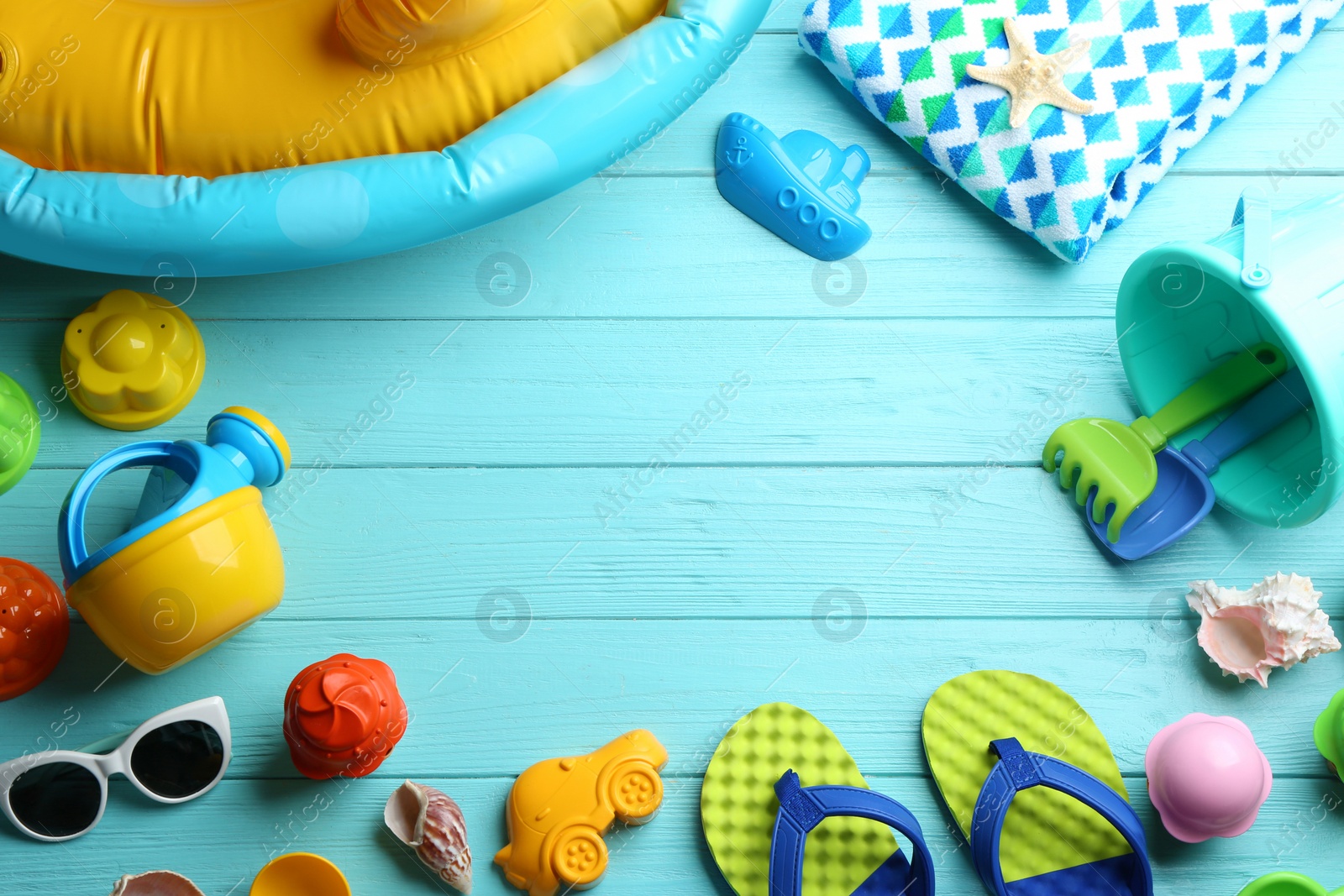 Photo of Flat lay composition with bright beach toys on color wooden background. Space for text