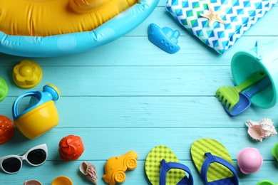 Flat lay composition with bright beach toys on color wooden background. Space for text