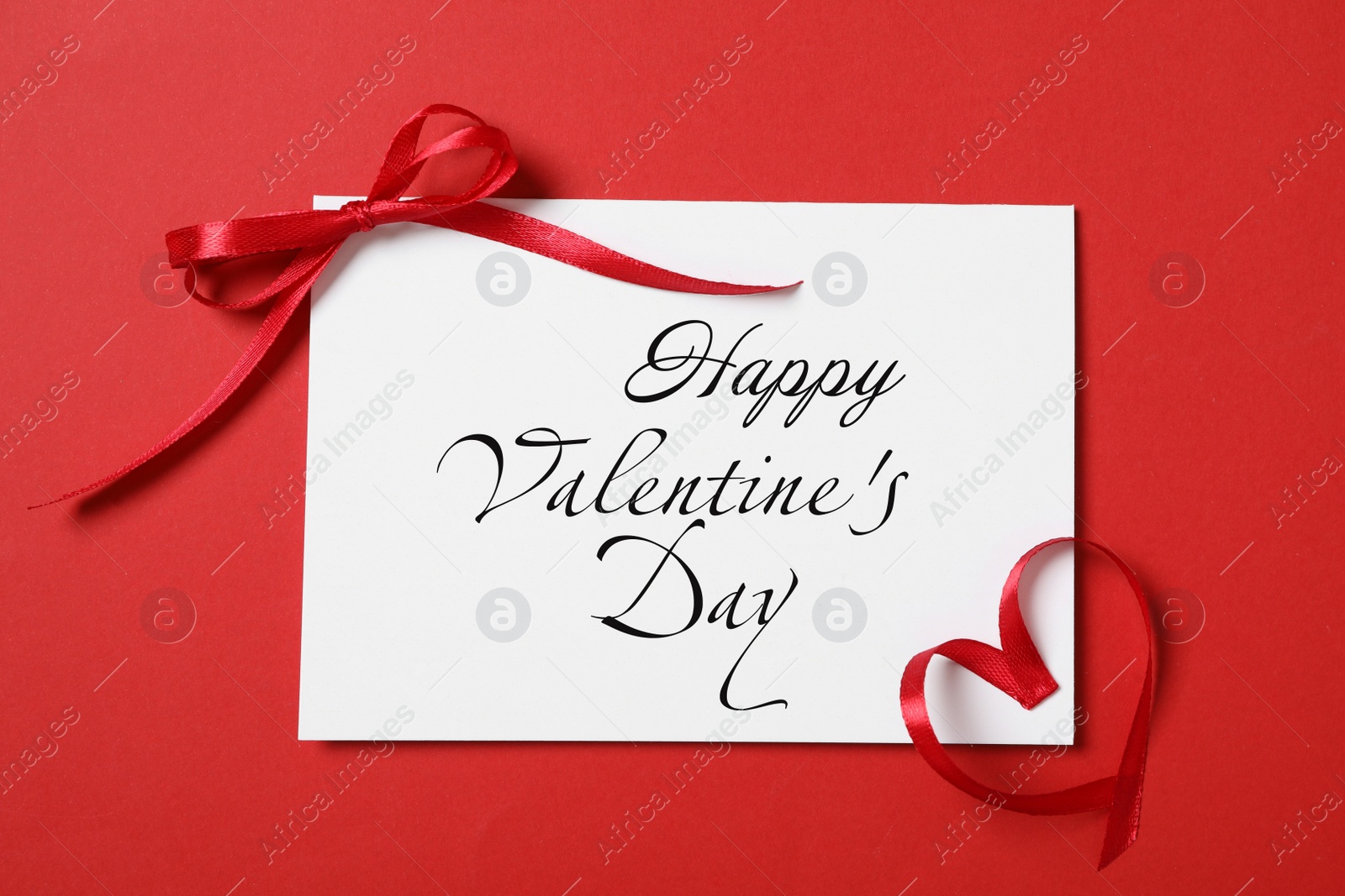 Image of Greeting card with text Happy Valentine's Day and ribbons on red background, flat lay