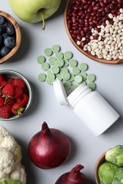 Food and bottle of prebiotic pills on grey background, flat lay