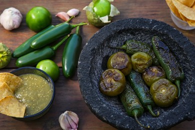 Different ingredients for cooking tasty salsa sauce on wooden table, above view