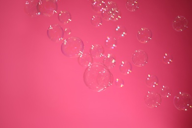Beautiful translucent soap bubbles on pink background