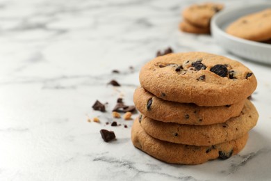 Photo of Delicious chocolate chip cookies on white marble table. Space for text