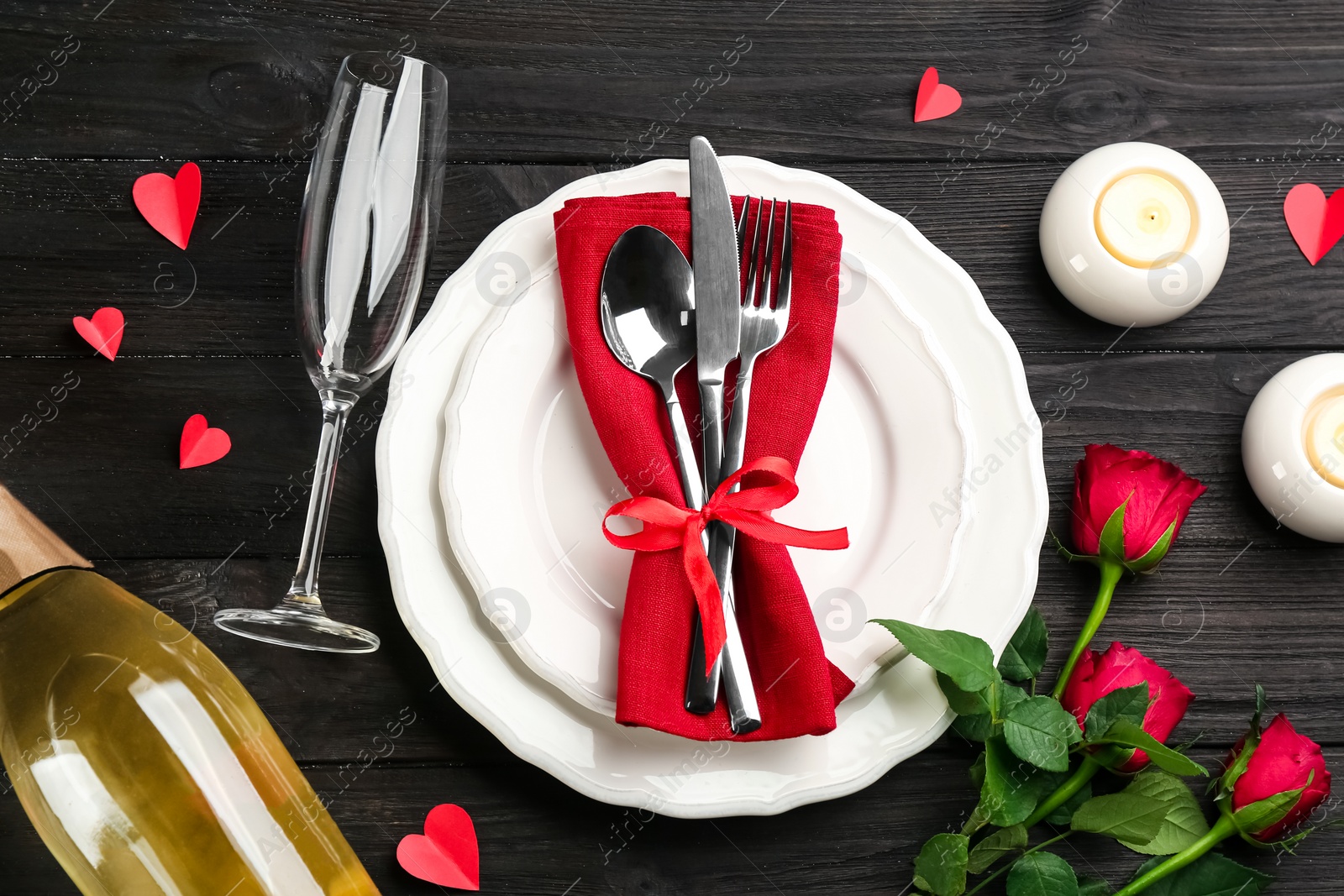 Photo of Beautiful table setting for Valentine's Day dinner on black wooden background, flat lay