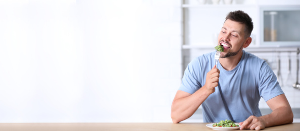 Image of Portrait of happy man eating broccoli salad in kitchen, space for text 
