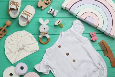 Photo of Flat lay composition with baby clothes and accessories on green wooden table