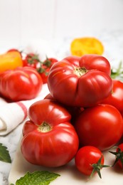 Photo of Many different ripe tomatoes on table, closeup