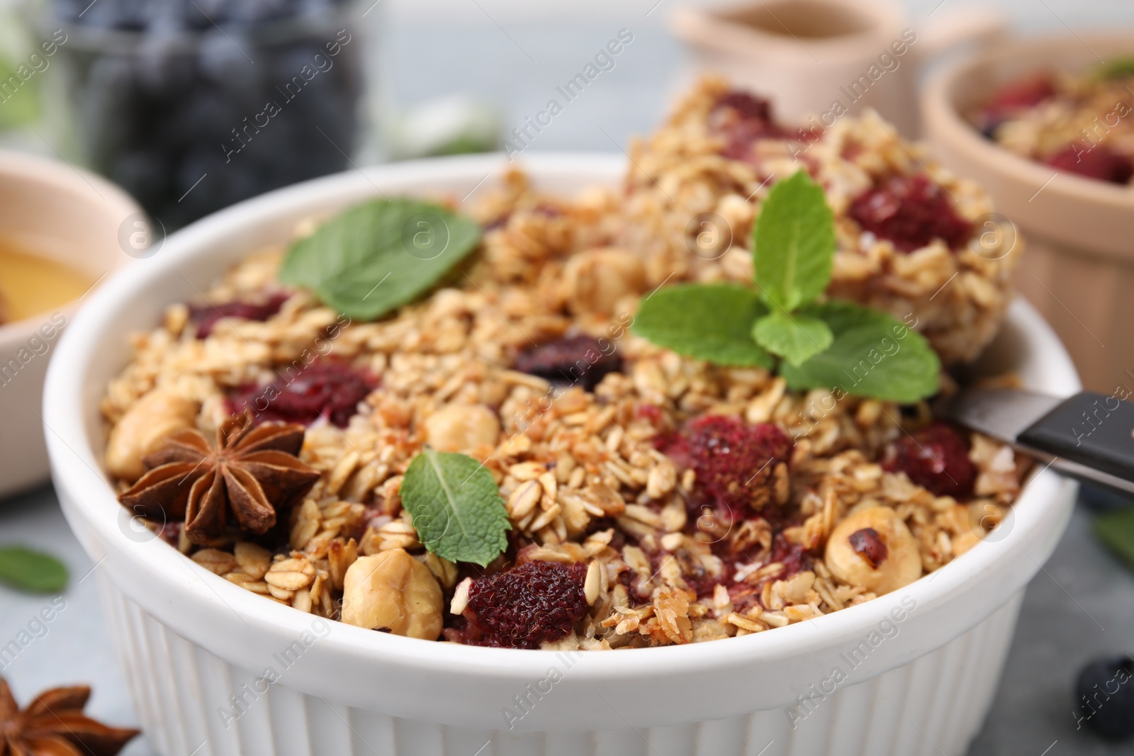 Photo of Tasty baked oatmeal with berries, nuts and anise star on table, closeup