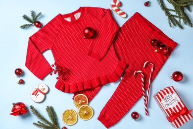 Flat lay composition with cute Christmas baby clothes on light blue background