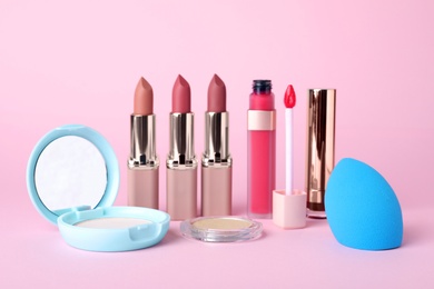 Different luxury decorative cosmetics on pink background