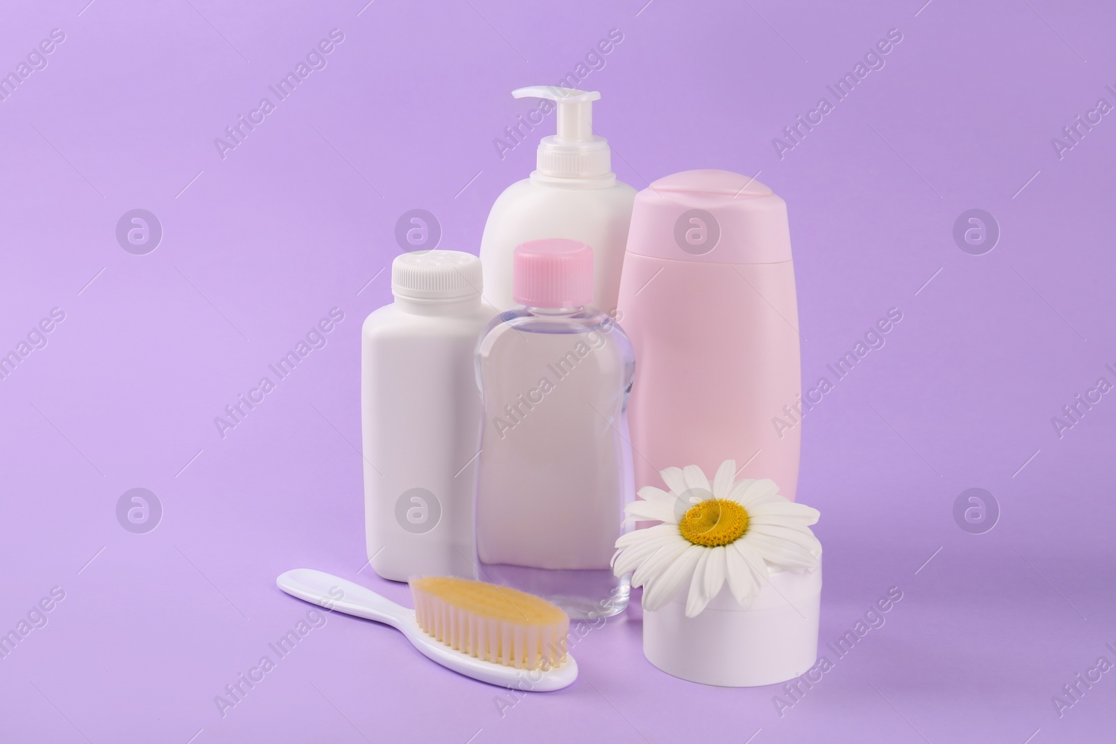 Photo of Different skin care products for baby and flower on violet background