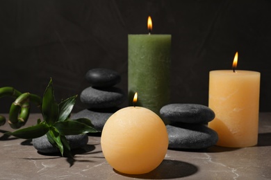 Composition with candles and spa stones on marble table