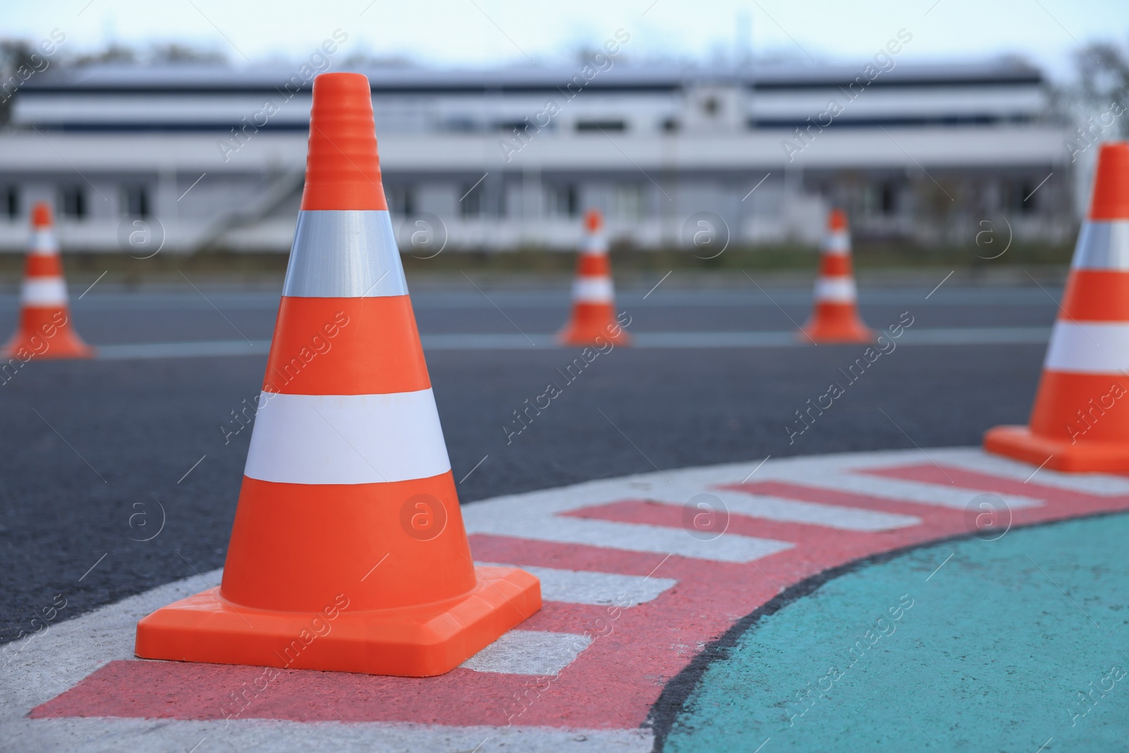 Photo of Driving school test track with marking lines, focus on traffic cone