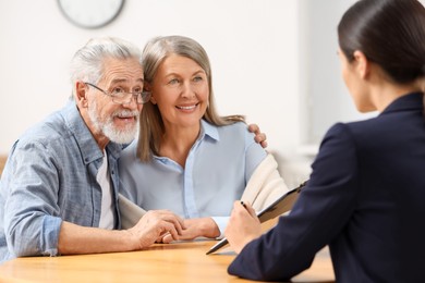 Notary consulting senior couple about Last Will and Testament in office