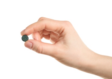 Photo of Woman holding spirulina pill on white background, closeup