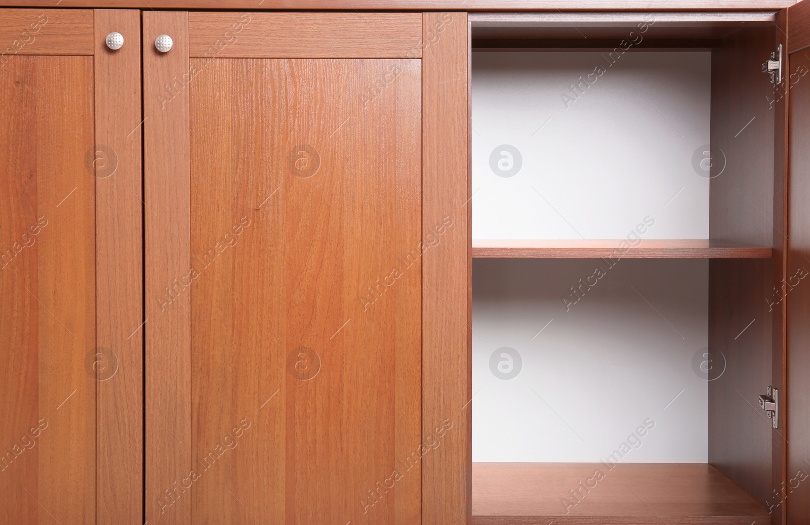 Photo of Open wooden wardrobe with empty shelves, closeup