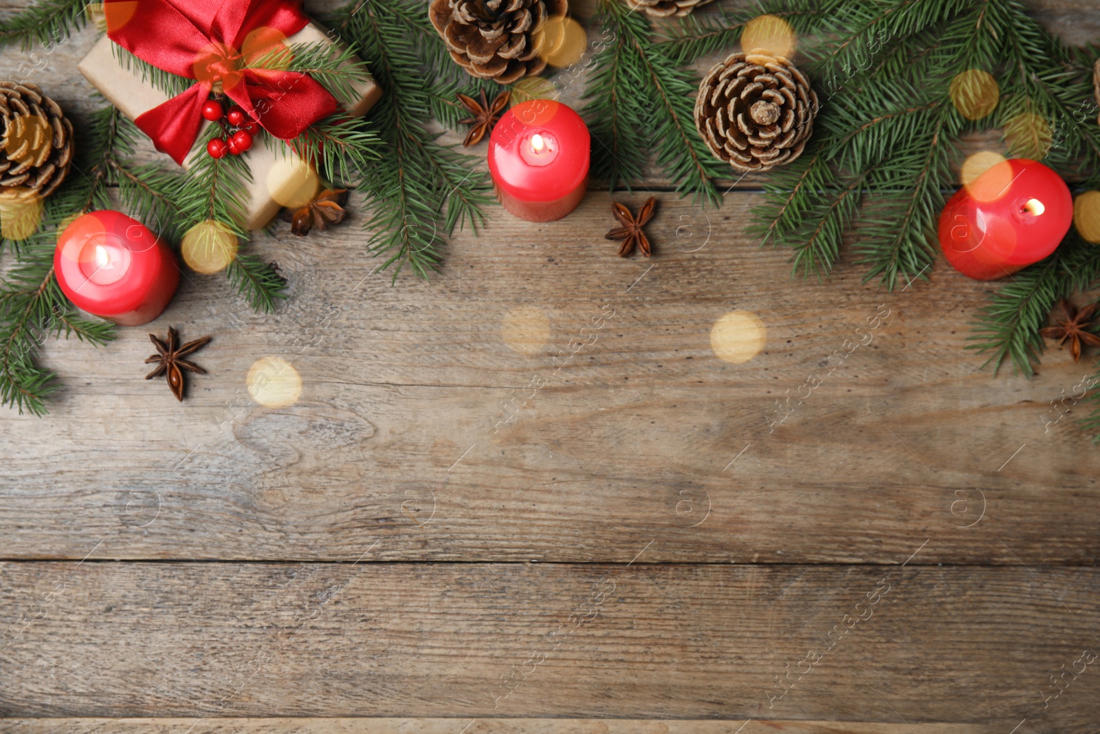 Photo of Christmas greeting card with space for text. Flat lay composition of fir tree branches and festive decor on wooden background