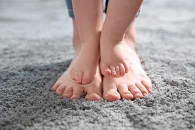 Baby doing first steps with mother's help, closeup