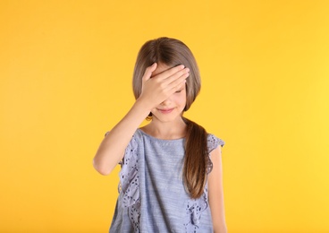 Photo of Portrait of emotional little girl on yellow background