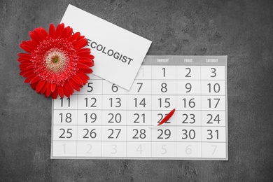 Flat lay composition with calendar and red flower on grey background. Gynecological care