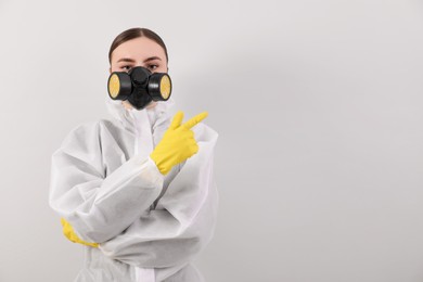 Photo of Woman in protective suit pointing at mold on wall. Space for text