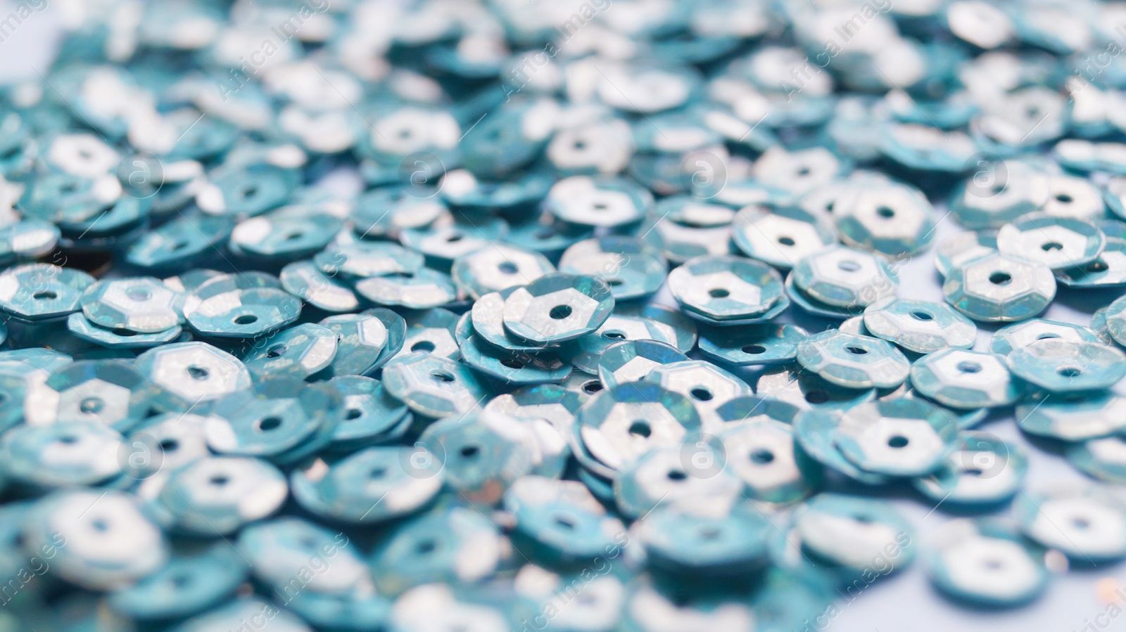 Photo of Many beautiful turquoise sequins as background, closeup