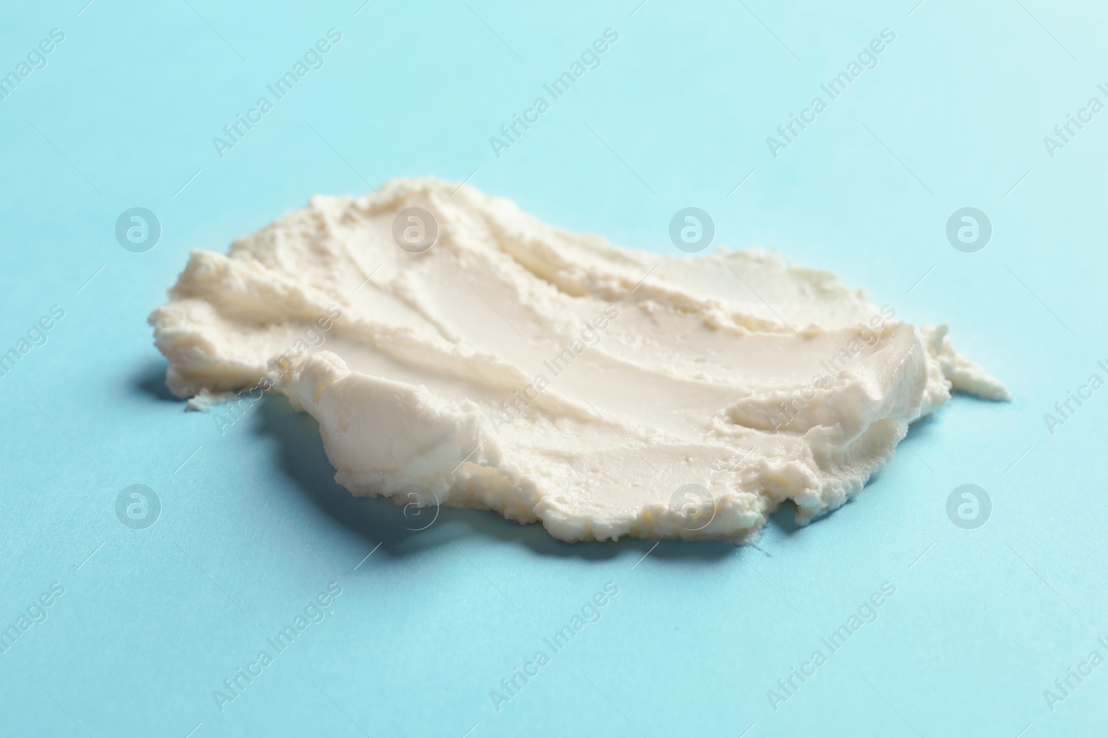 Photo of Smear of tasty cream cheese on color background