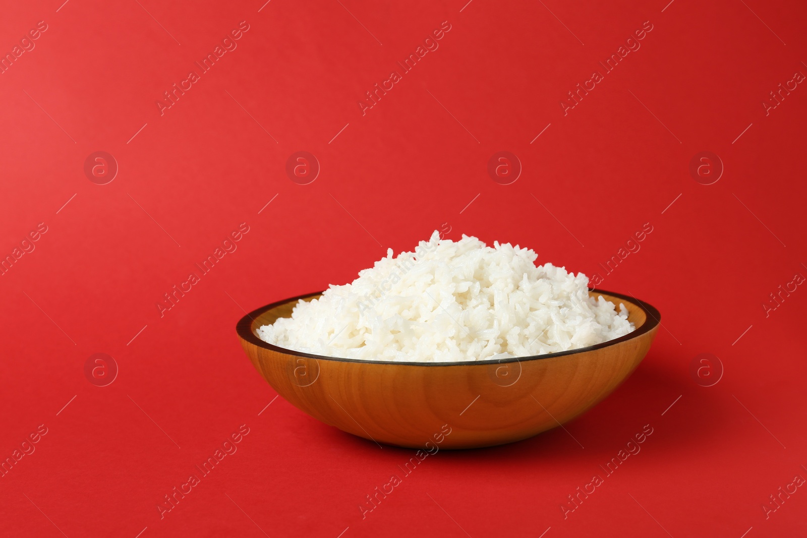 Photo of Bowl of boiled rice on color background. Space for text