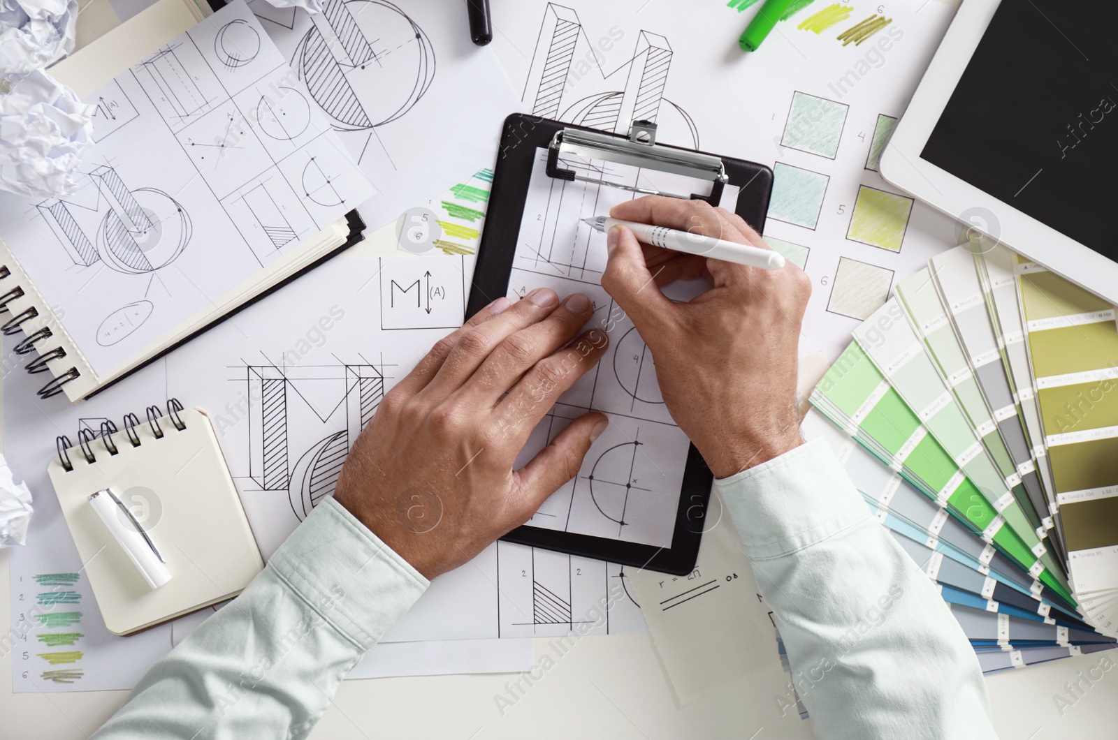 Photo of Male designer working at white table, top view