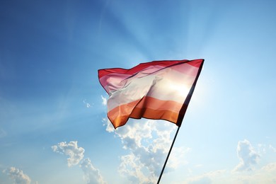 Bright lesbian flag fluttering against blue sky