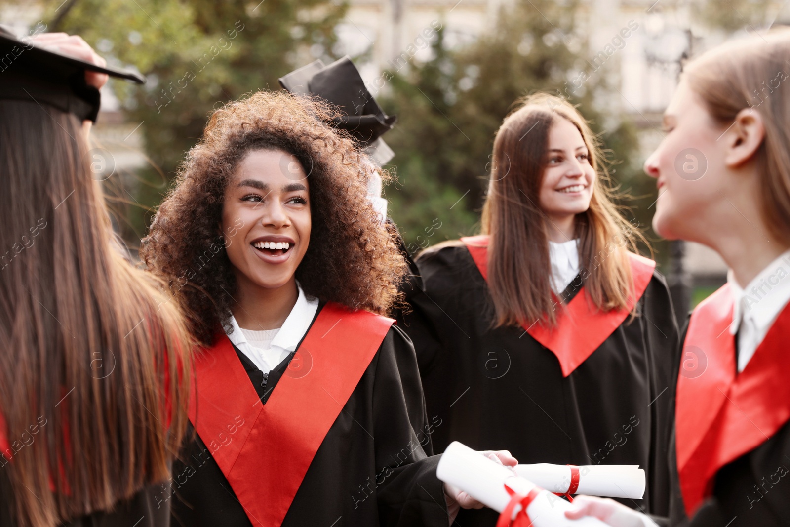 Photo of Group of happy students outdoors. Graduation ceremony