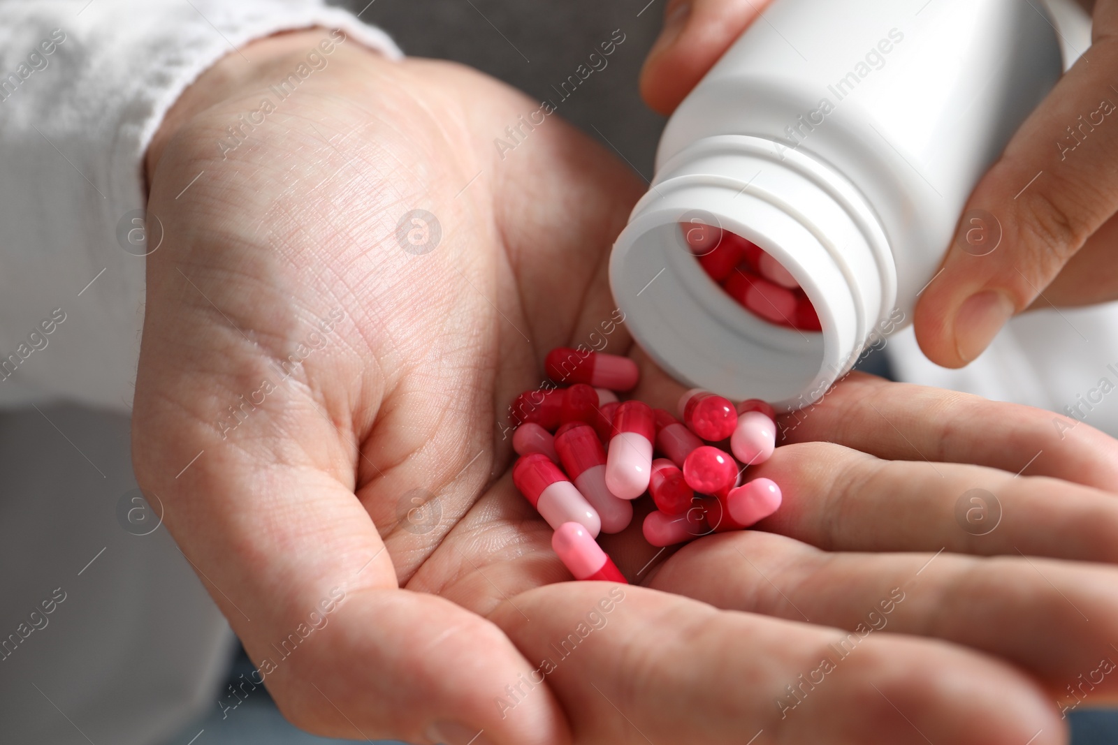 Photo of Man pouring pills from bottle, closeup view