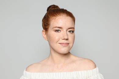 Photo of Portrait of young woman with beautiful face on grey background