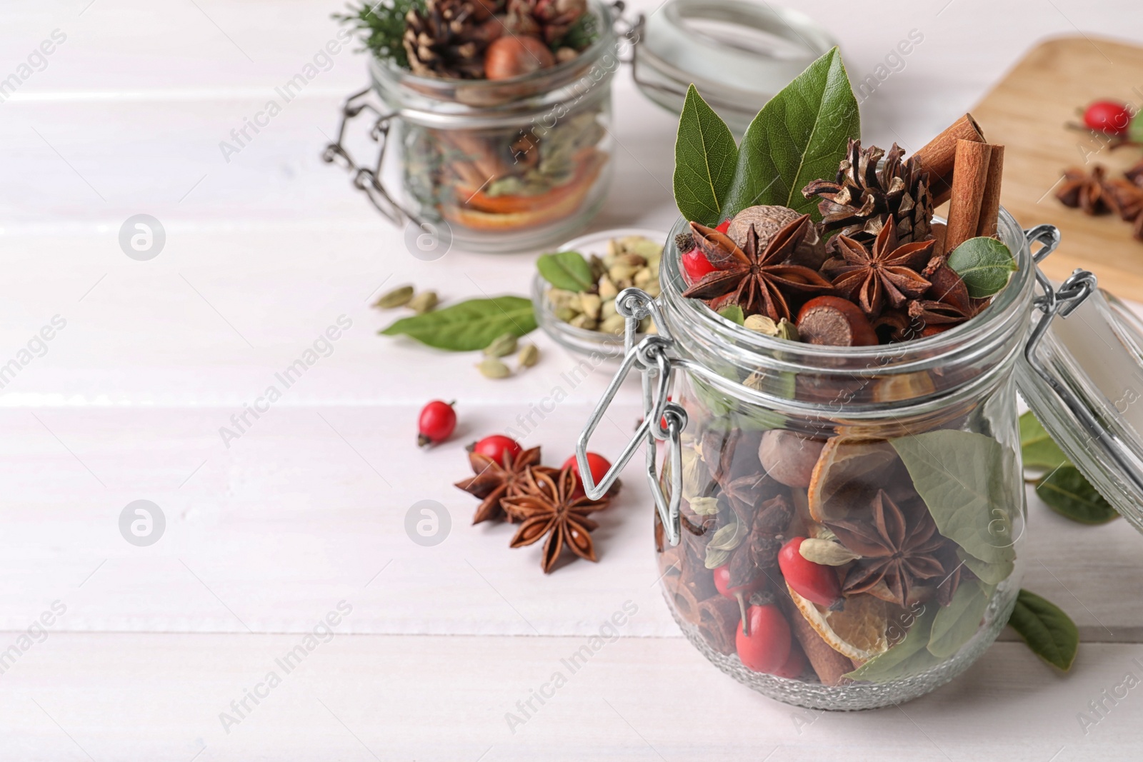 Photo of Aroma potpourri with different spices on white wooden table, space for text