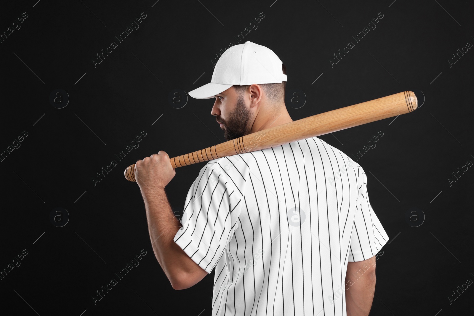 Photo of Man in stylish white baseball cap holding bat on black background