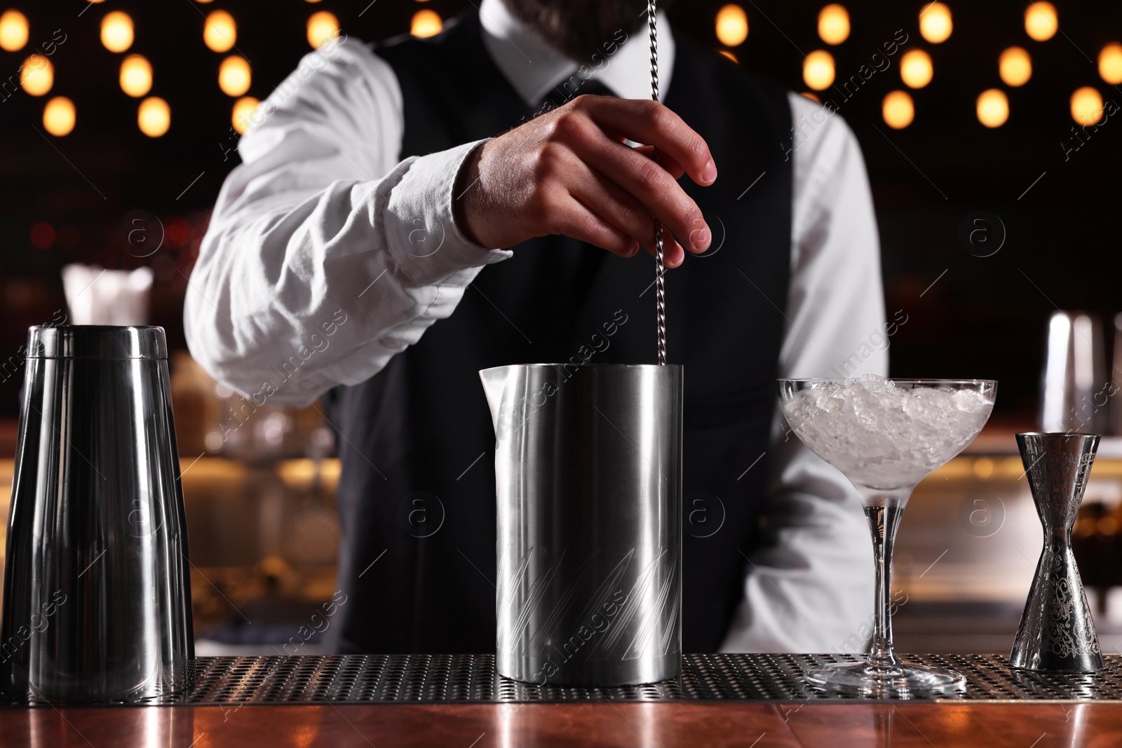 Photo of Bartender preparing fresh alcoholic cocktail at bar counter, closeup