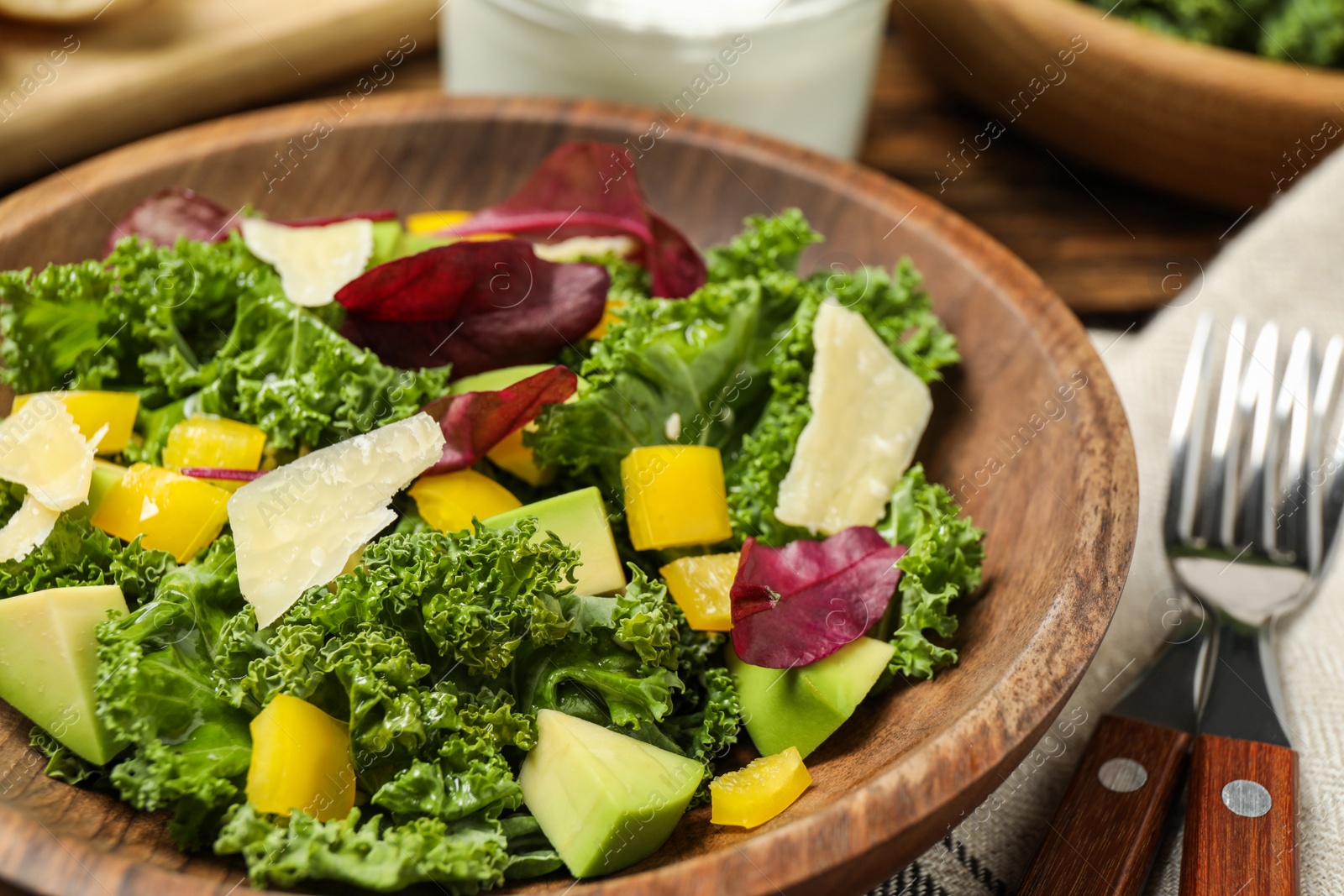 Photo of Delicious kale salad in wooden bowl, closeup