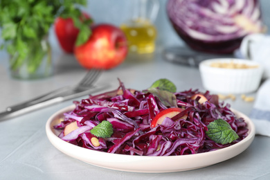 Photo of Fresh red cabbage salad served on light grey table