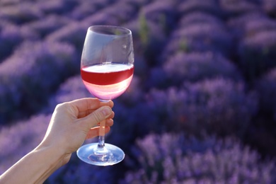 Photo of Woman with glass of wine in lavender field
