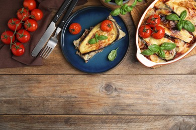 Photo of Delicious eggplant lasagna served on wooden table, flat lay. Space for text