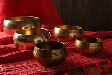 Tibetan singing bowls and red fabric on wooden table