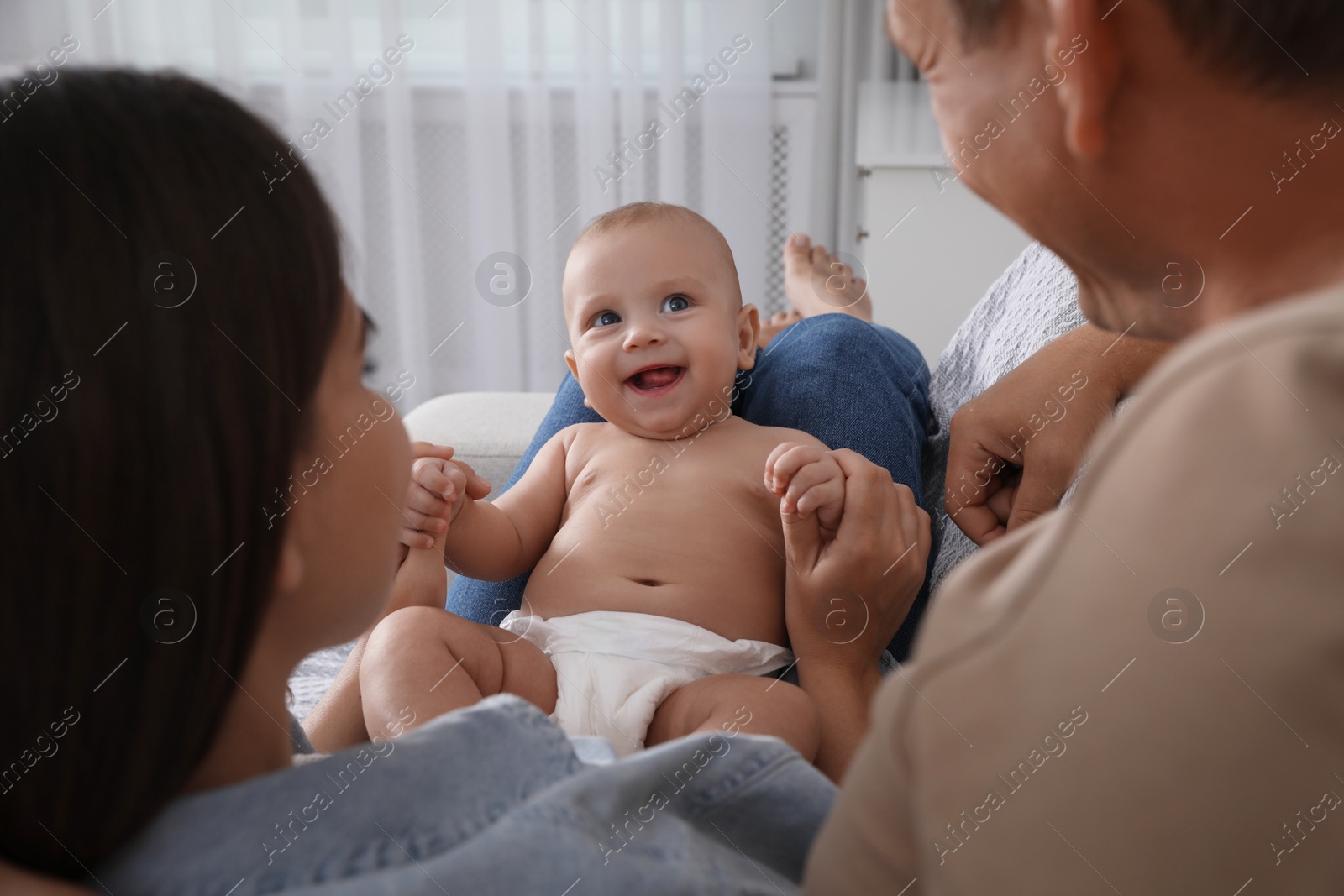 Photo of Happy family with their cute baby at home