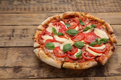 Photo of Delicious Caprese pizza on wooden table, space for text