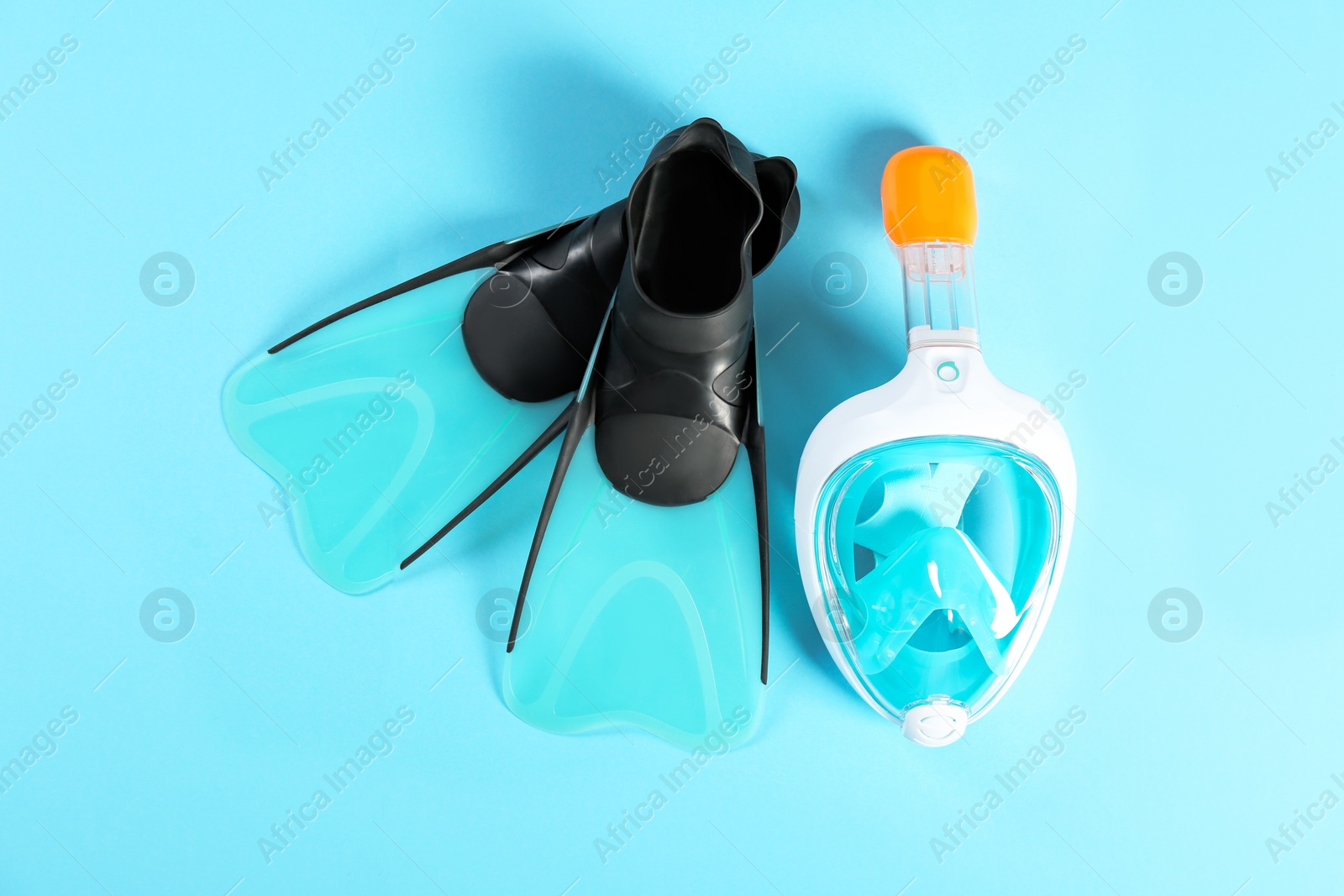 Photo of Swimming flippers and mask on color background, top view