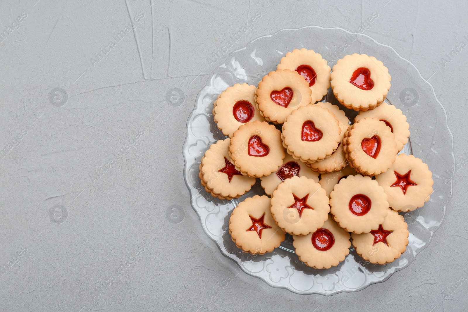 Photo of Traditional Christmas Linzer cookies with sweet jam on plate, top view