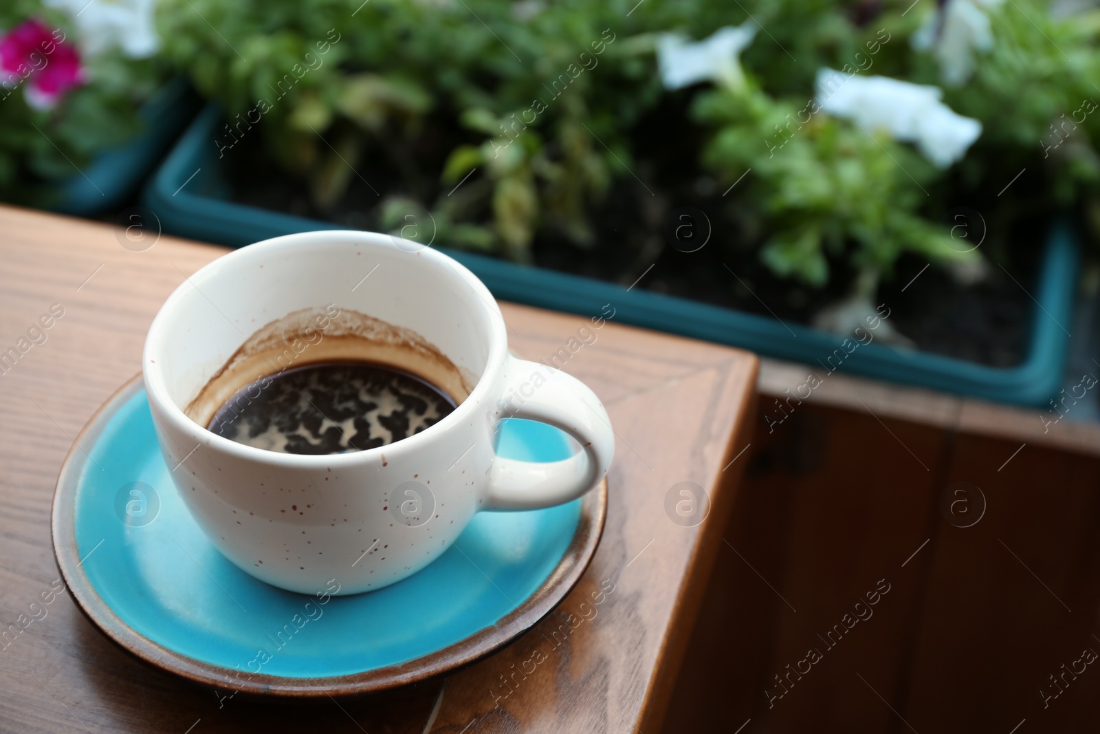 Photo of Cup of fresh aromatic coffee on wooden table