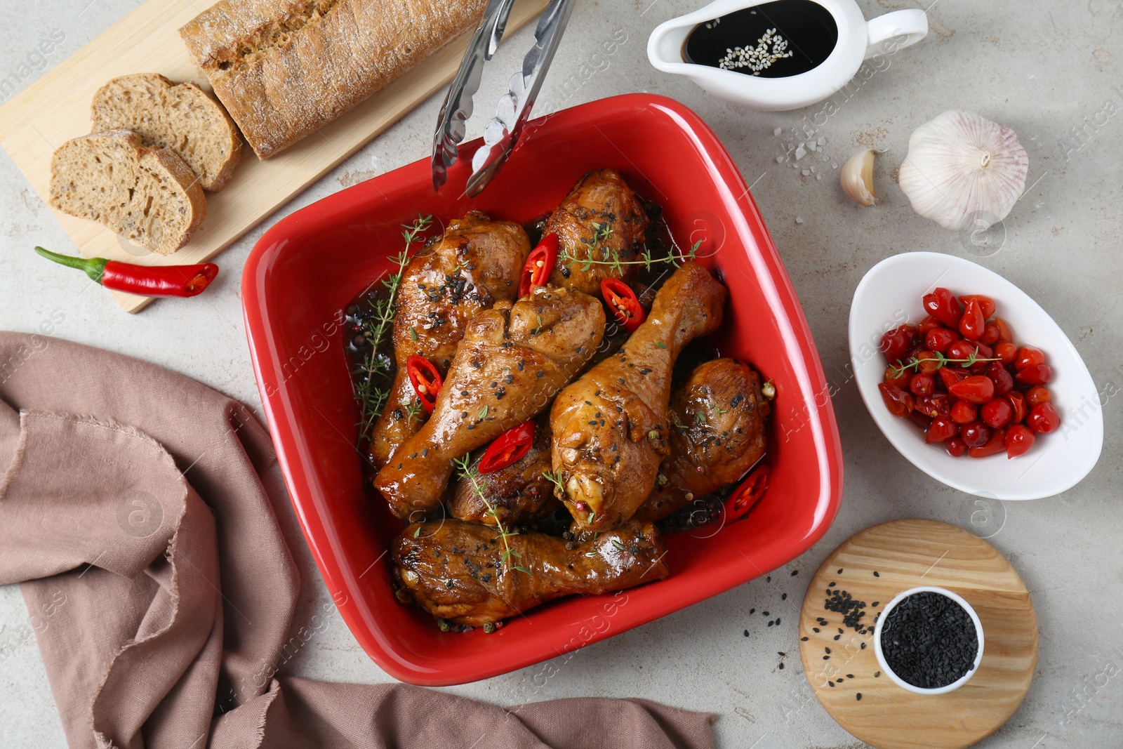 Photo of Flat lay composition of chicken legs glazed with soy sauce and ingredients on light table