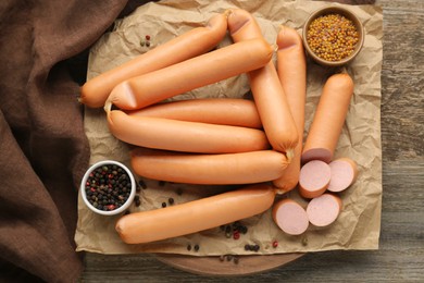 Photo of Tasty sausages, peppercorns and mustard on wooden table, flat lay. Meat product